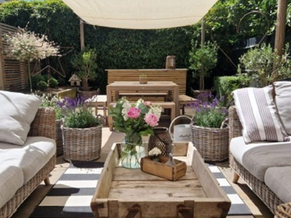 An outdoor room with dining and lounge seating under a canopy